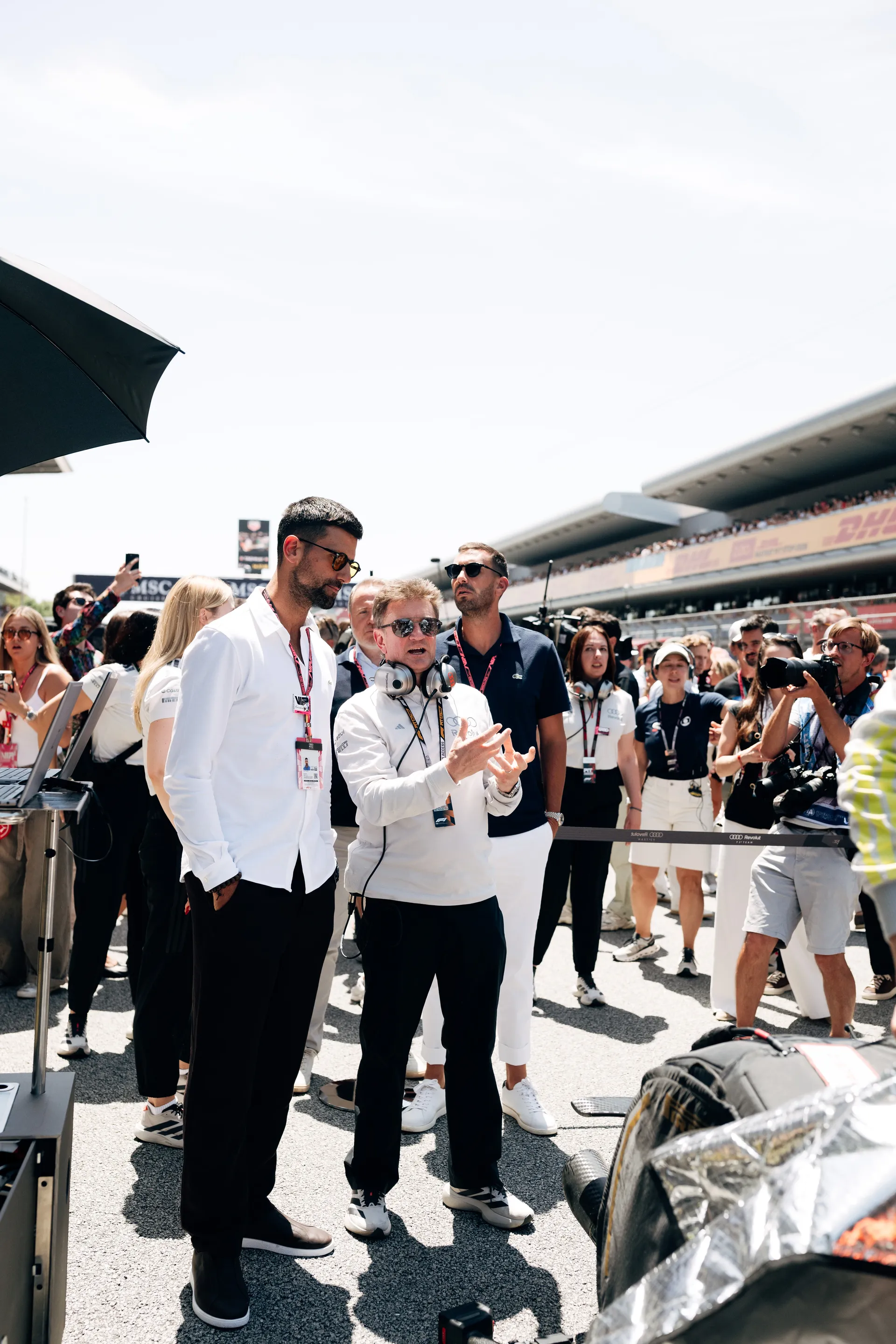 Allan McNish speaking with Novak Đoković on the Barcelona grid during pre-race preparations.