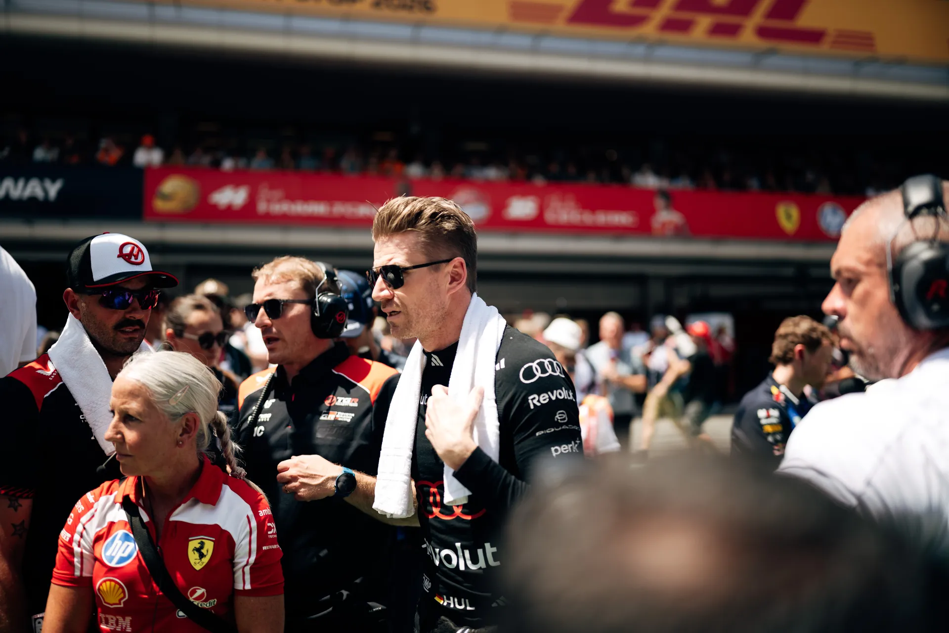 Nico Hulkenberg on the grid wearing Audi Revolut F1® Team kit, speaking with team members before the race.