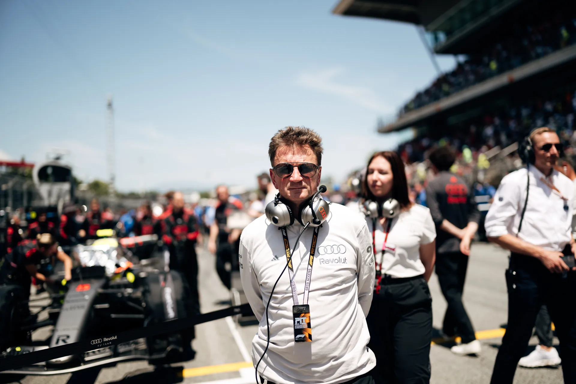 Allan McNish standing on the Barcelona grid observing pre-race operations with the Audi R26 in the background.