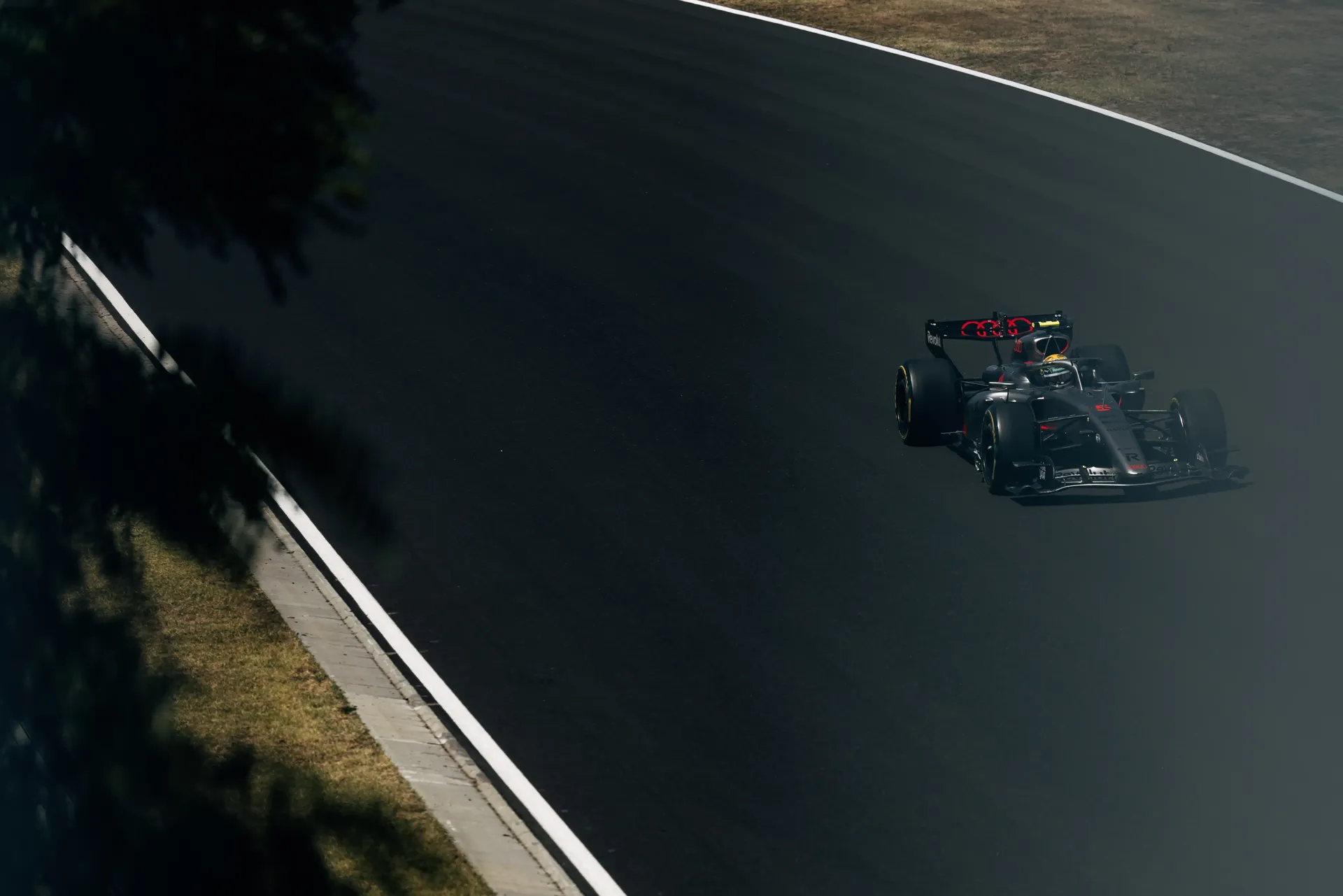 The Audi Revolut F1® Team Audi R26 drives through a shaded section of the Hungaroring during FP3.