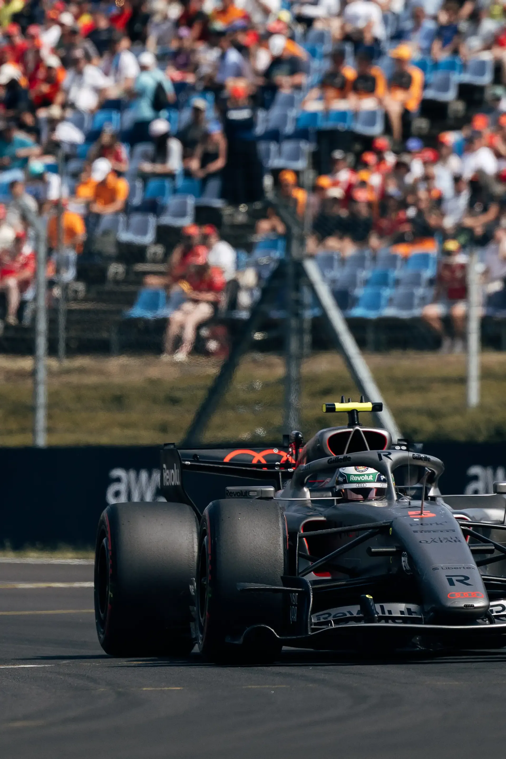 The Audi Revolut F1® Team Audi R26 drives through the Hungaroring during the Hungarian Grand Prix with spectators filling the grandstands.