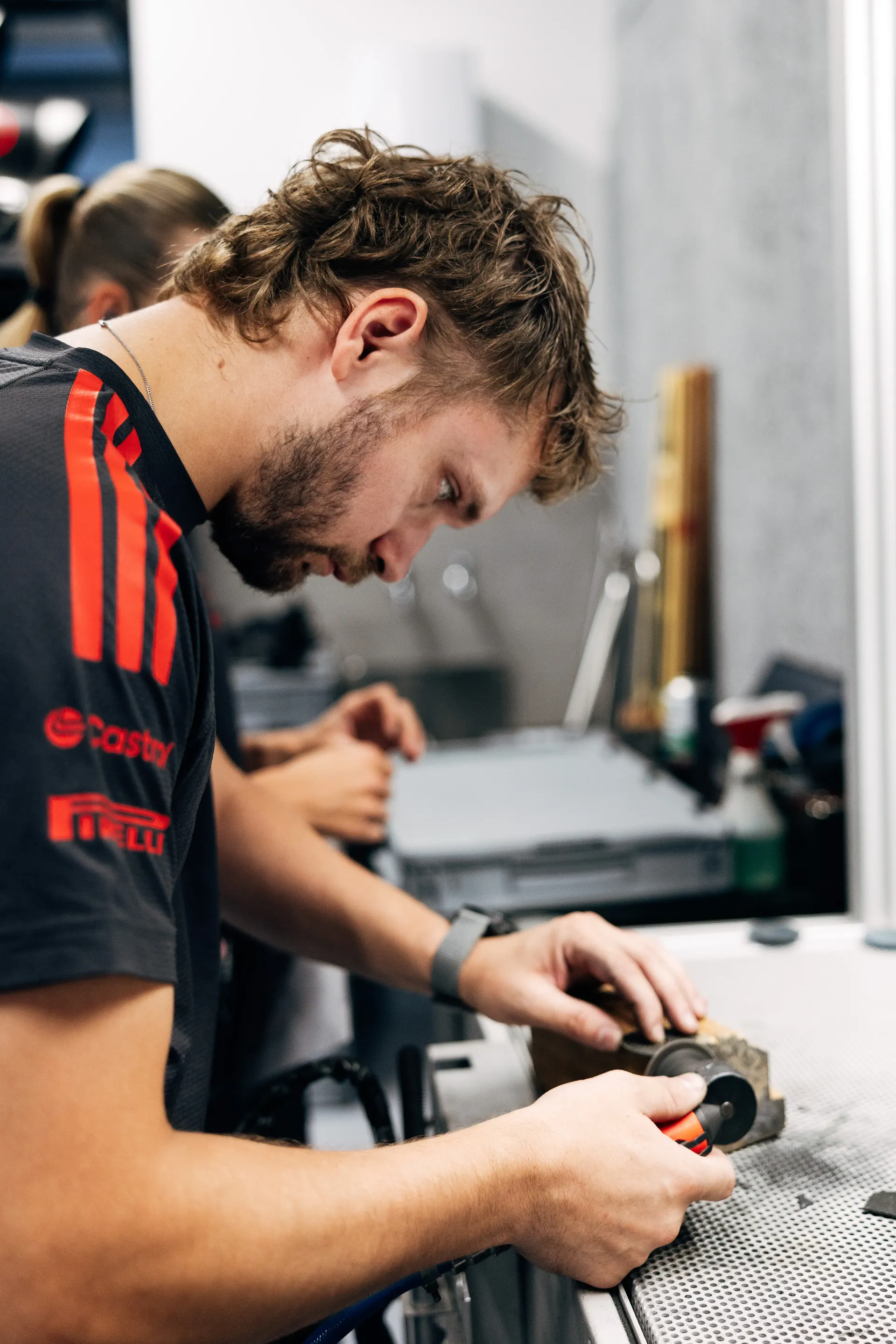 Audi Revolut F1® Team mechanic works on components in the Hungaroring garage before track action.