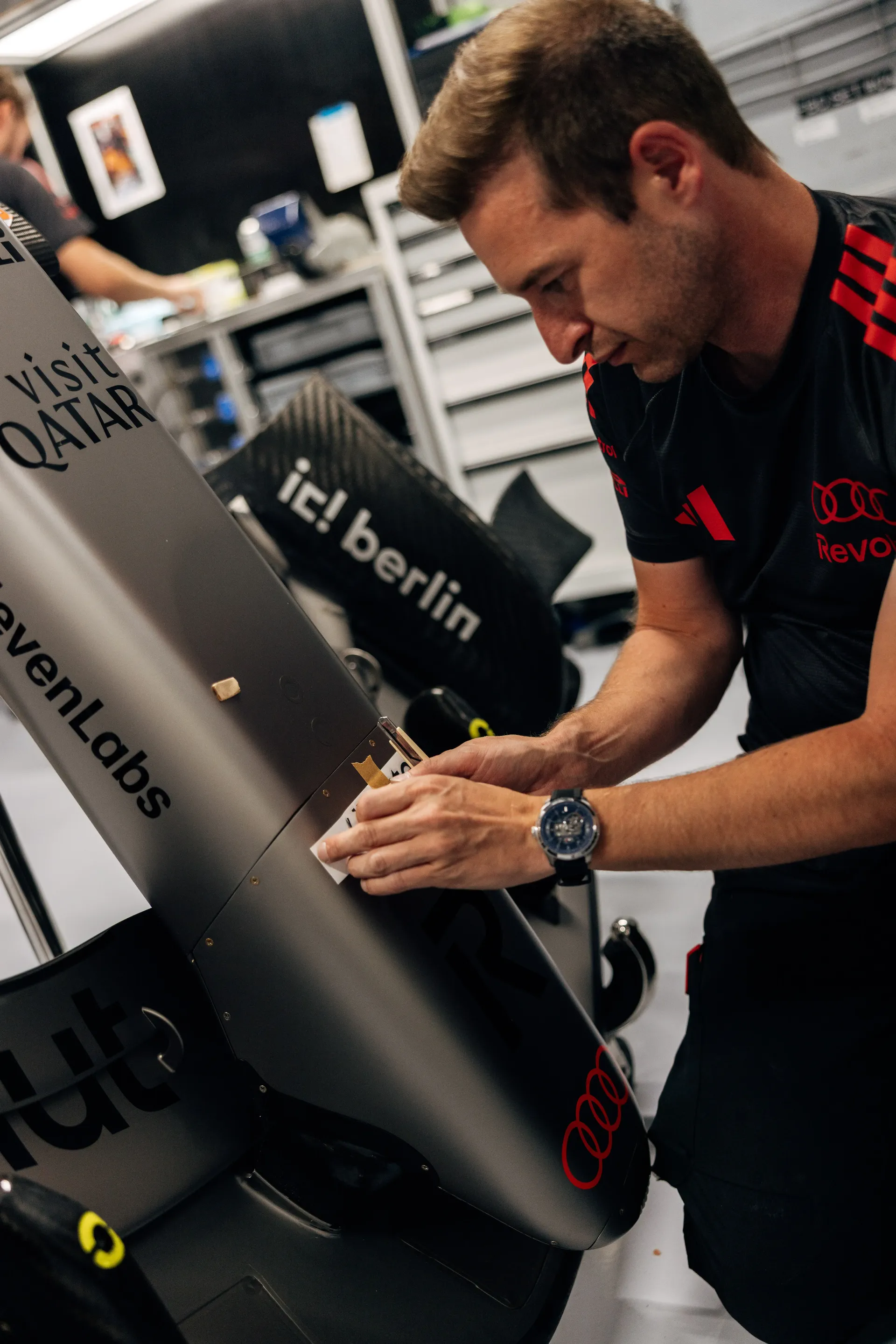 Mechanic adjusts the front section of the Audi R26 in the garage ahead of the Hungarian Grand Prix.