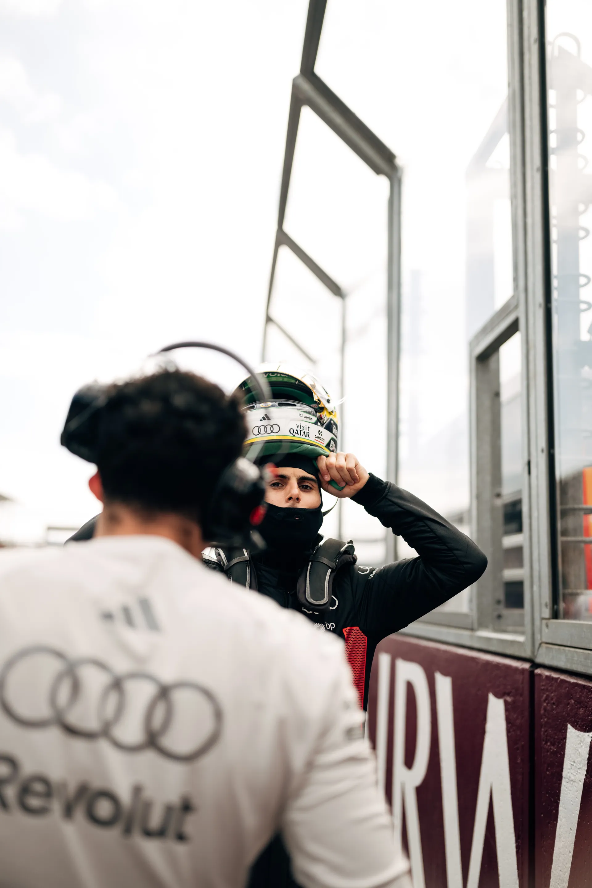 Audi Revolut F1® Team driver Gabriel Bortoleto adjusts helmet beside the barrier on the Melbourne grid before the race.