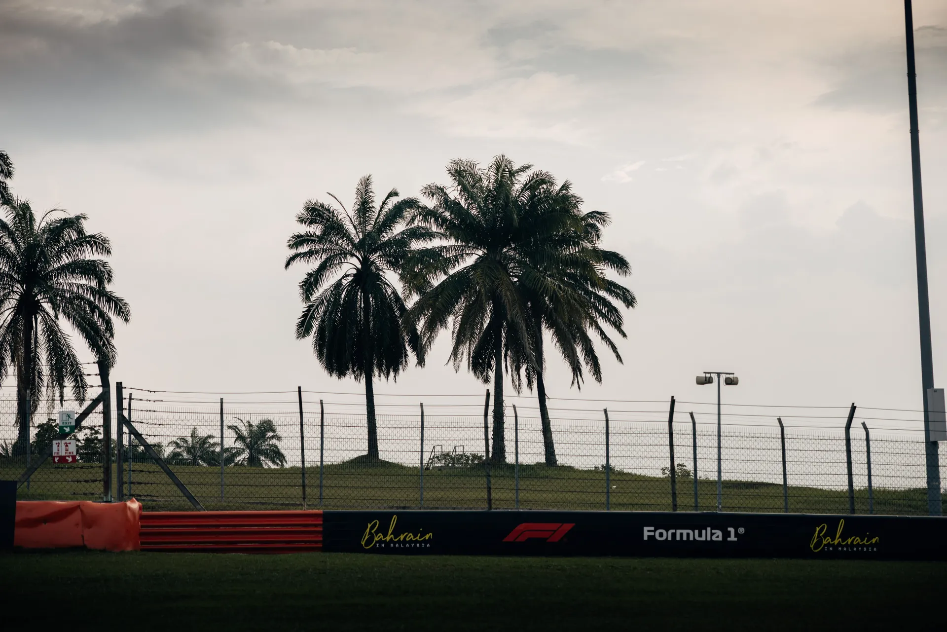 Palm trees and Formula 1 signage alongside Bahrain International Circuit