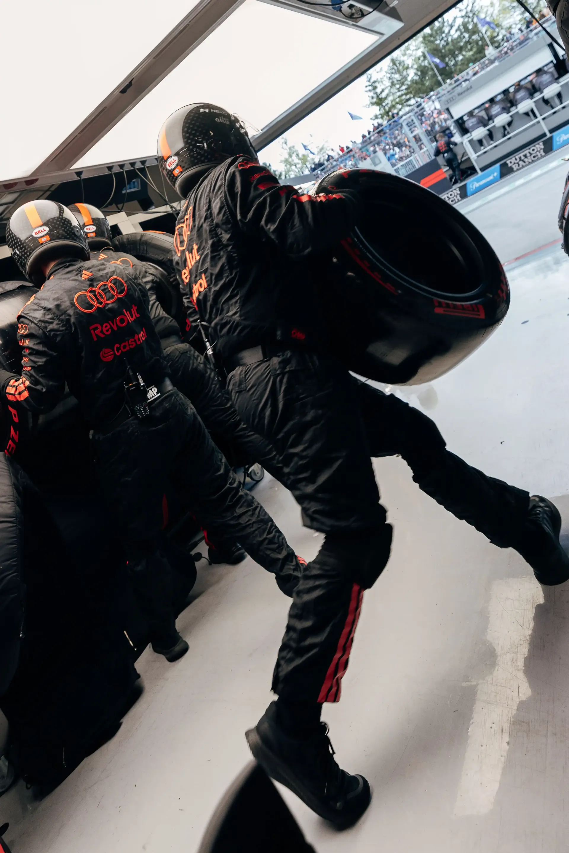 Close up of Audi Revolut F1® Team mechanic holding a tire and running inside the garage at the Canada Grand Prix 2026