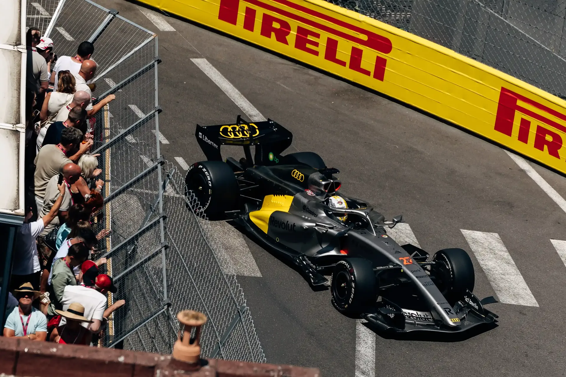 Audi Revolut F1® Team car R26 on track during Monaco Grand Prix FP1, passing spectators and barriers on the Monaco street circuit.