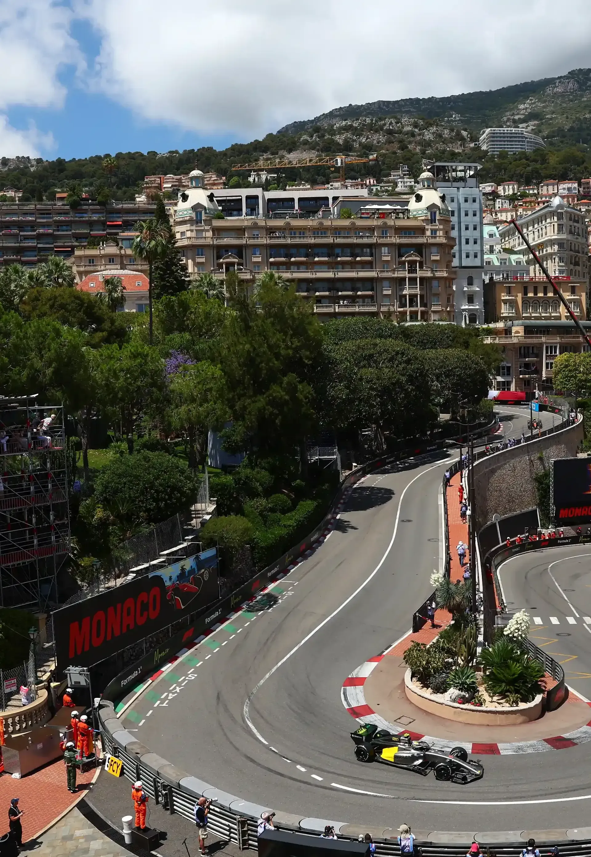 Audi Revolut F1® Team car R26 rounds Monaco's iconic Fairmont Hairpin during Monaco Grand Prix FP1, surrounded by city buildings and trackside infrastructure.