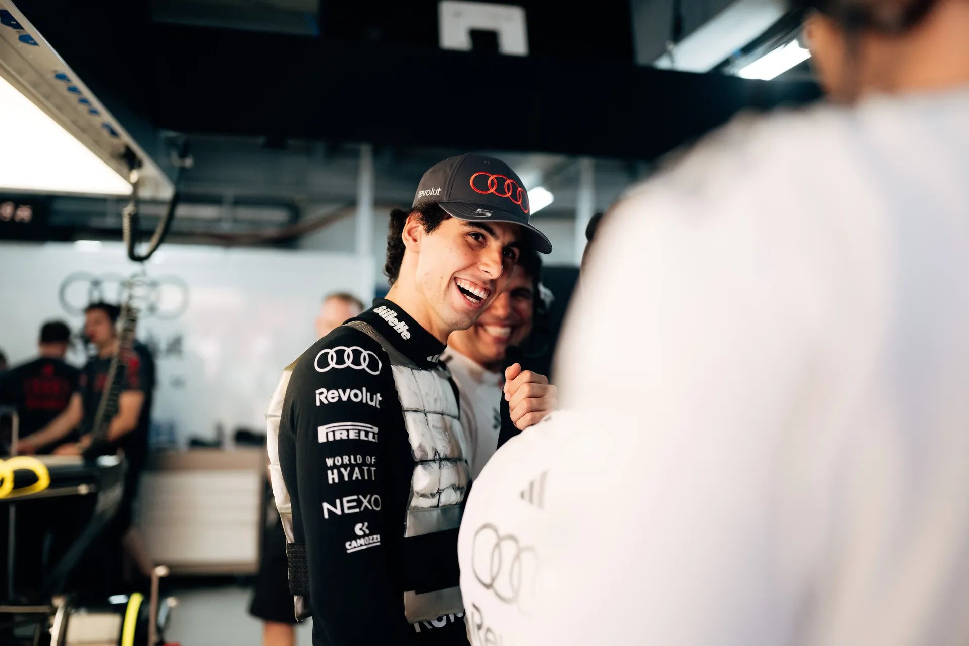 Gabriel Bortoleto driver at the Audi Revolut F1® Team laughing and talking to crew members inside the garage at the Monaco Grand Prix 2026