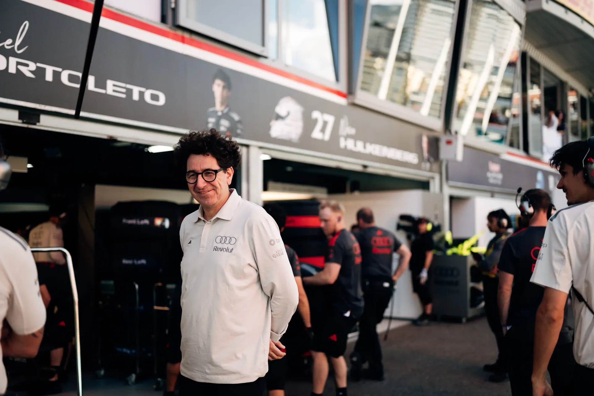 Audi Revolut F1® Team principal Mattia Binotto walking through the paddock between hospitality units and team garages.