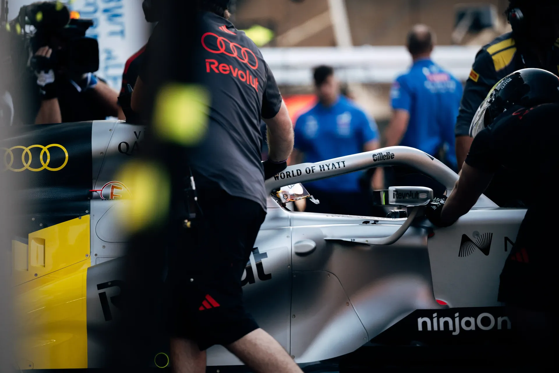 Mechanics work around the Audi Revolut F1® Team Formula 1 car inside the garage.
