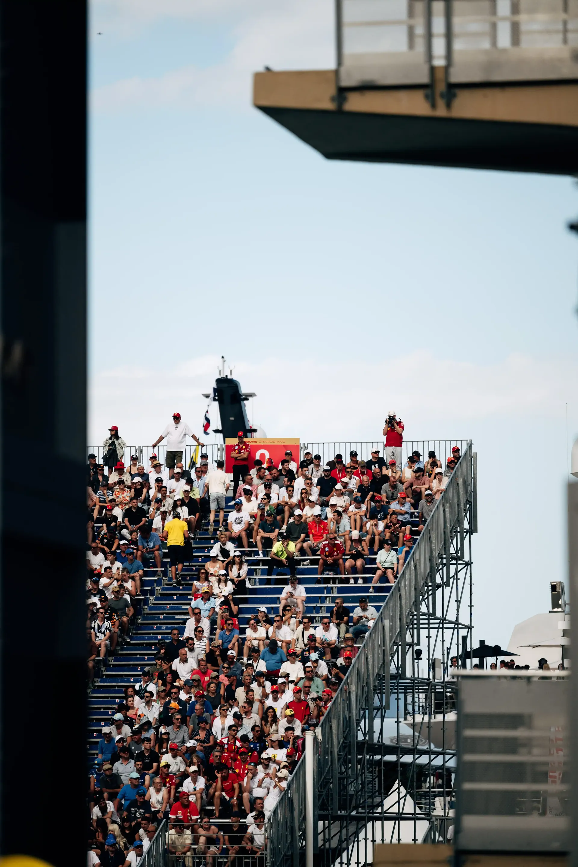 Crowded grandstand filled with spectators overlooking the Monaco street circuit.
