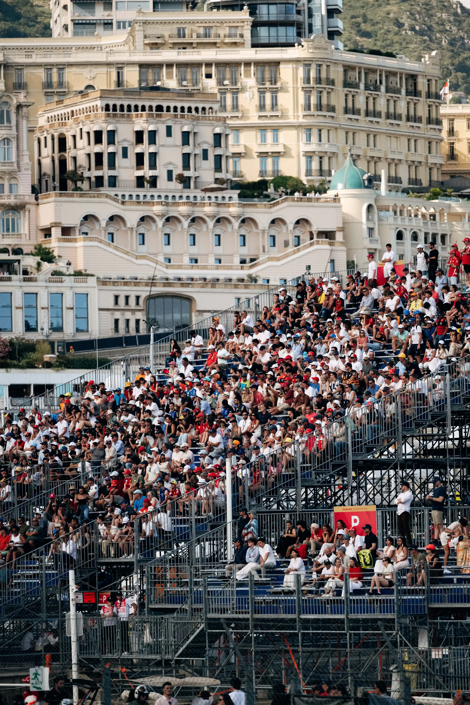 Spectators packed into grandstands with Monaco buildings rising in the background.