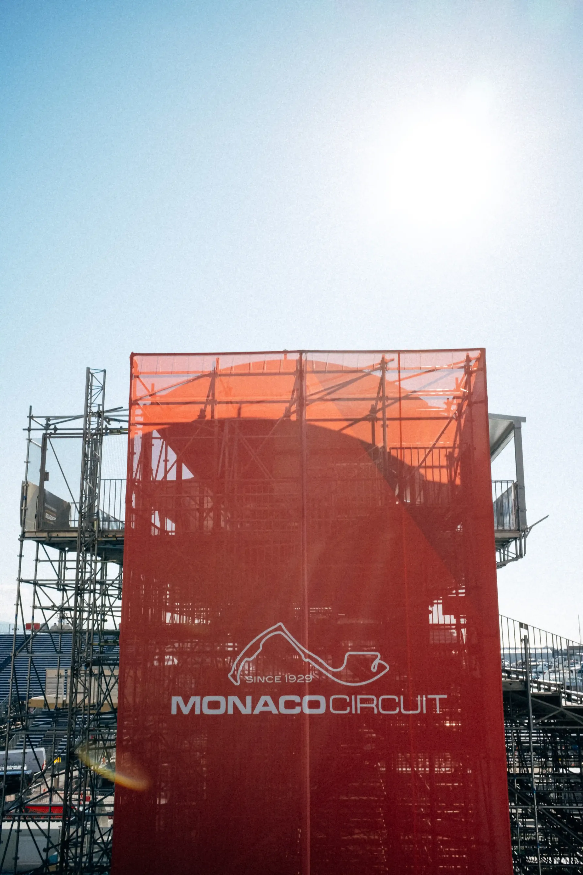Close-up of a red structure or vessel detail against a bright sky and harbor setting.