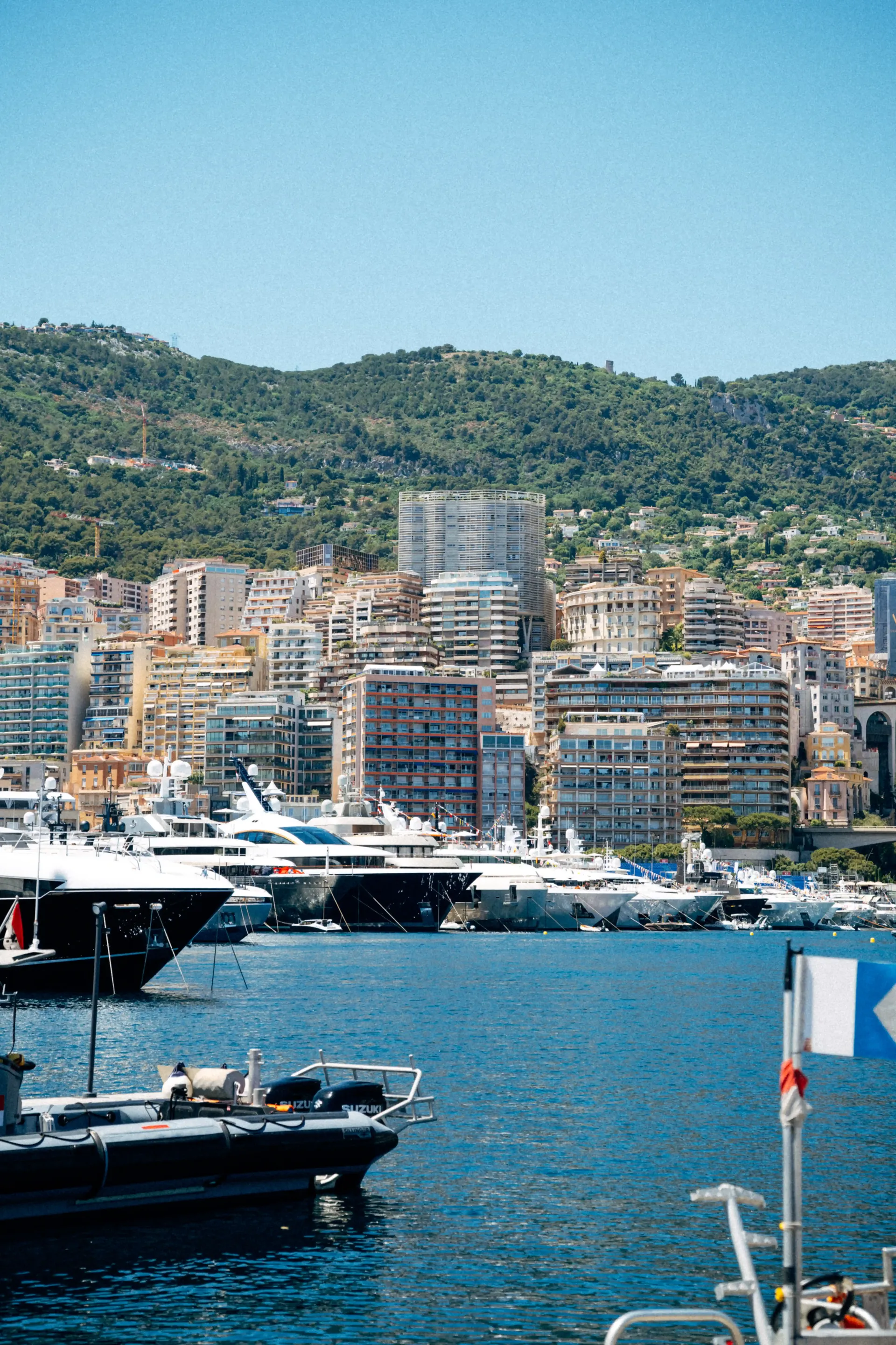 Monaco marina viewed from the waterfront, featuring yachts and coastal urban scenery.