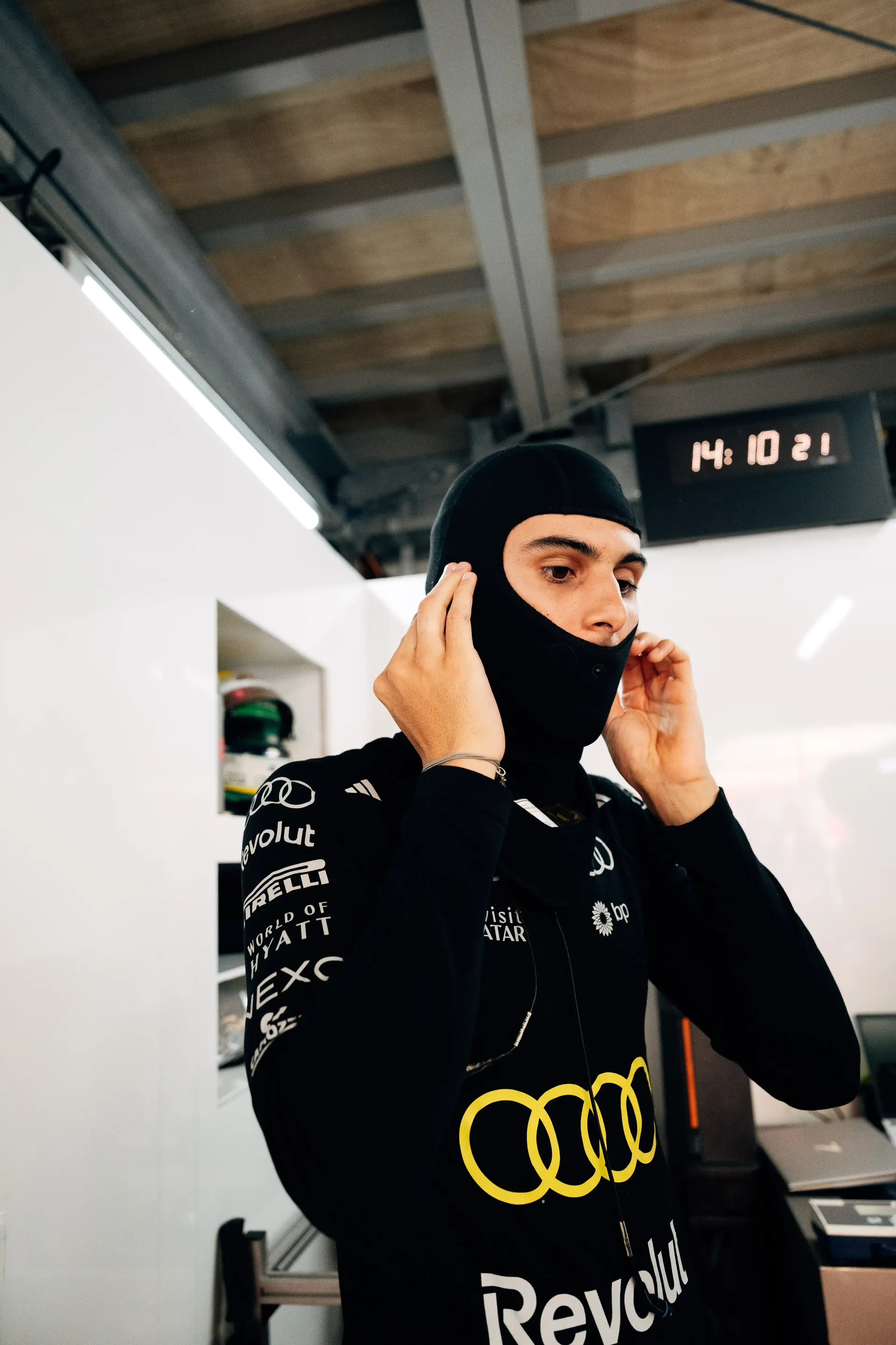 Audi Revolut F1® Team driver Gabriel Bortoleto adjusts a balaclava inside the garage before the Monaco Grand Prix.