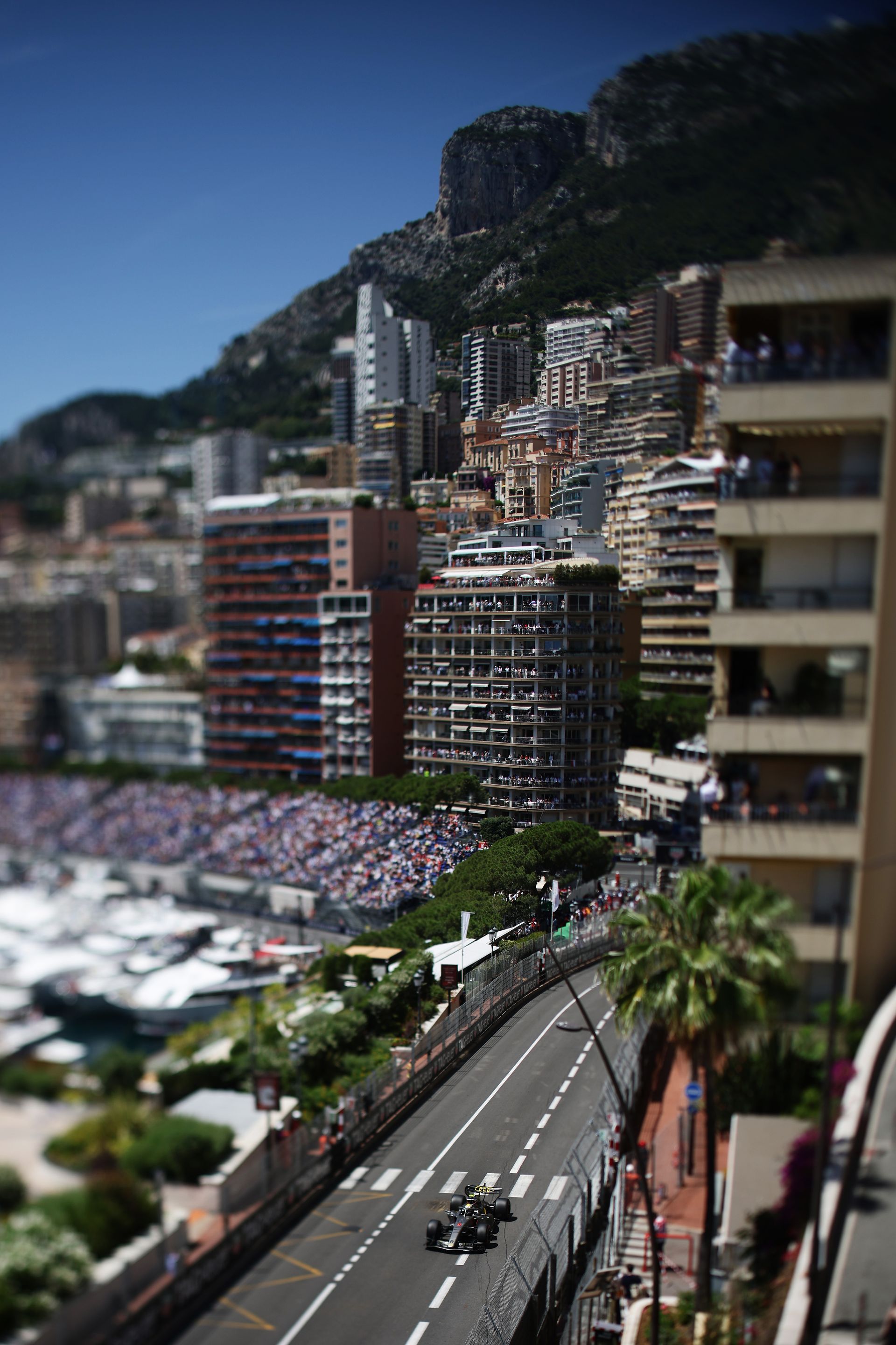 Audi Revolut F1® Team car R26 drives on the Circuit de Monaco featuring big buildings and the spectators arena in the back