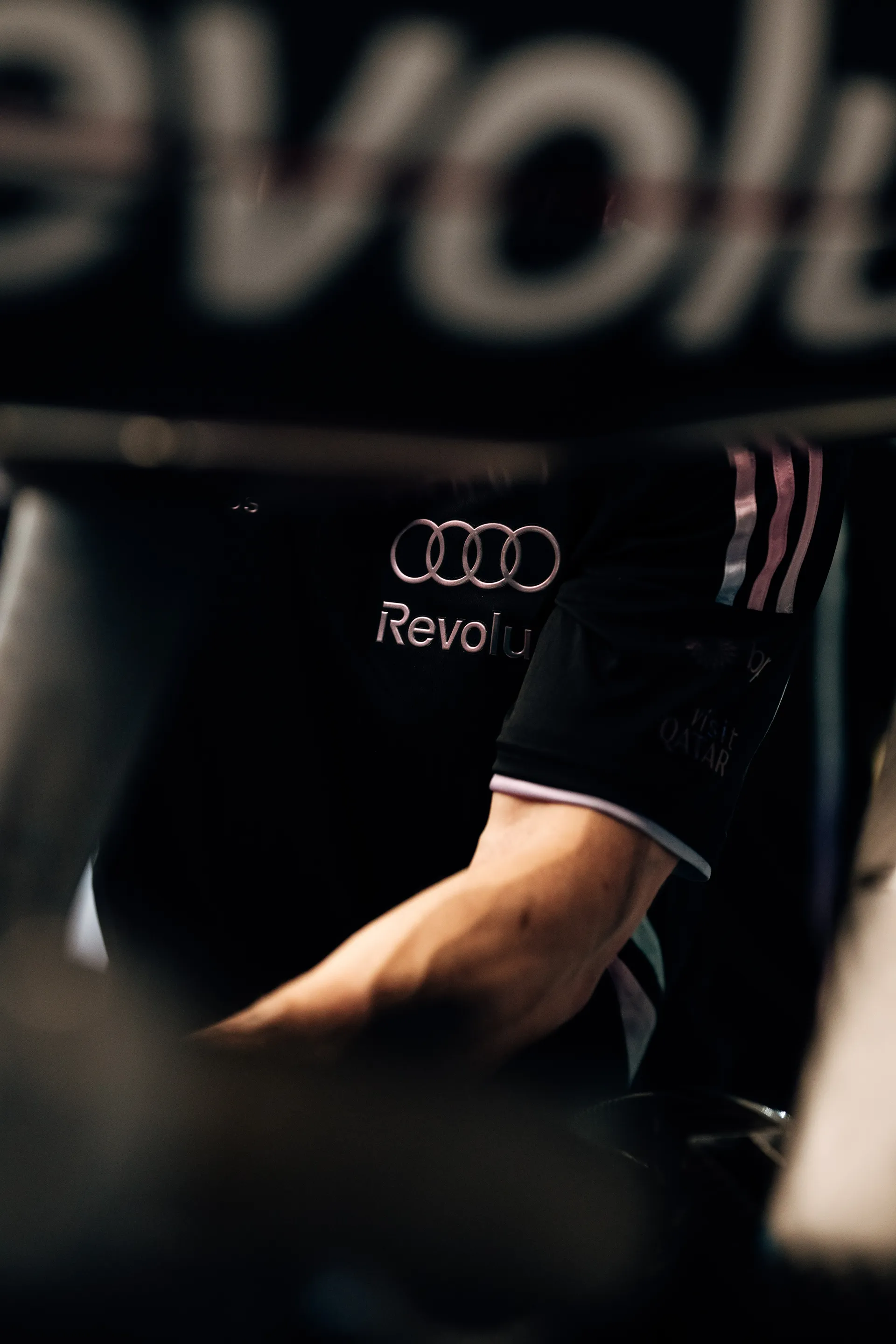 Close up of Audi Revolut F1® Team uniform with Audi rings and Revolut branding visible in low light.