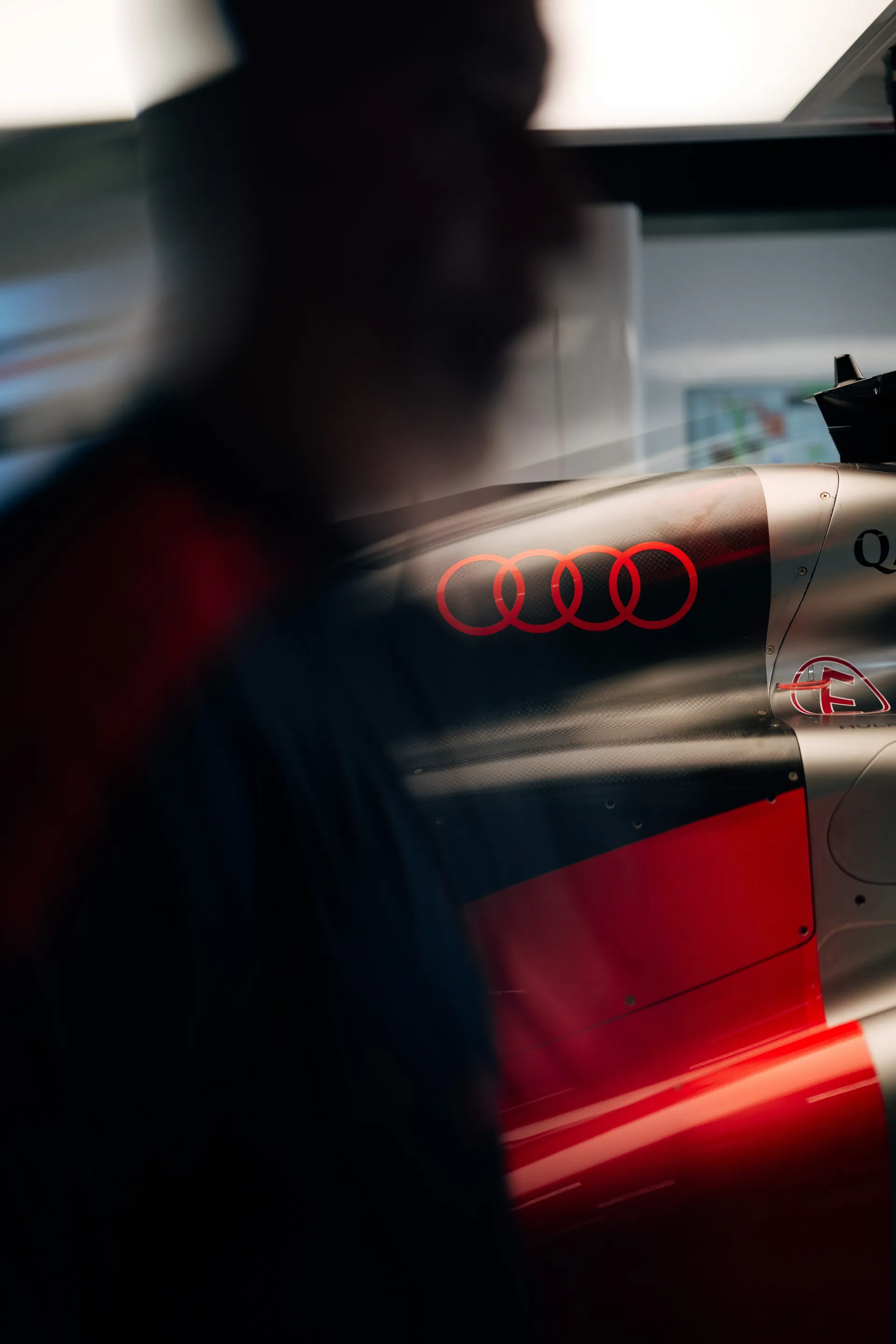 Close-up of the Audi rings on the Audi Revolut F1® Team Formula One car with motion blur across the bodywork.