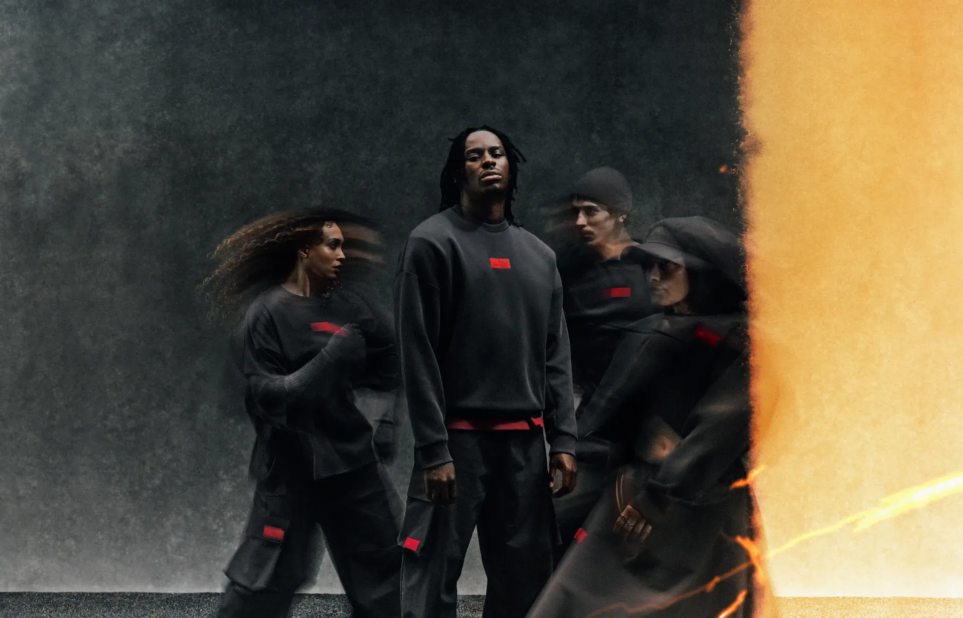 Four young models wearing adidas and Audi Revolut F1® Team Elevated Fanwear Collection and strike a very powerful pose