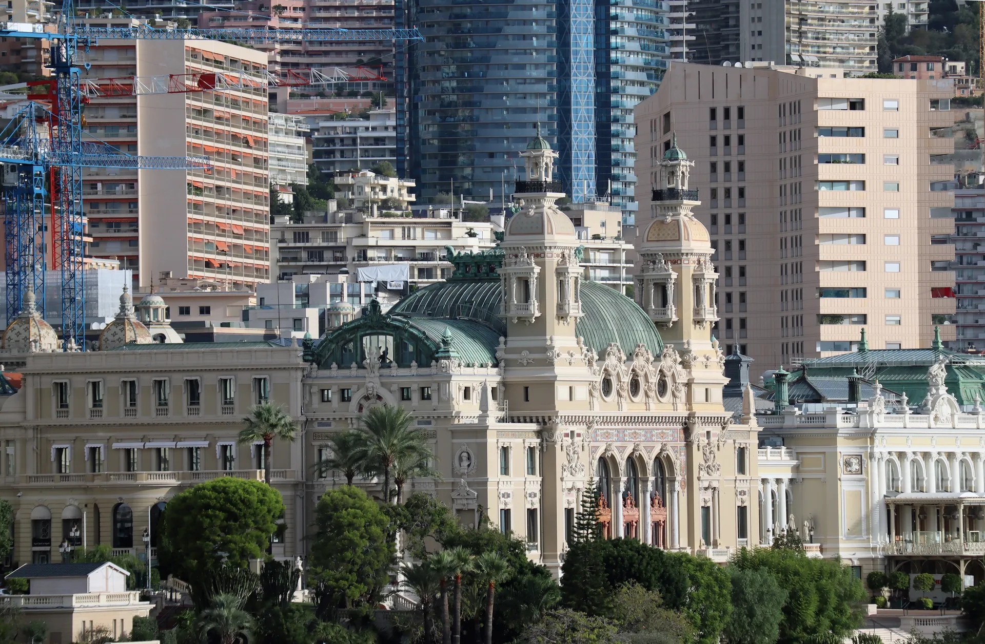 Historic Monaco building with domes and ornate architecture surrounded by modern skyscrapers.