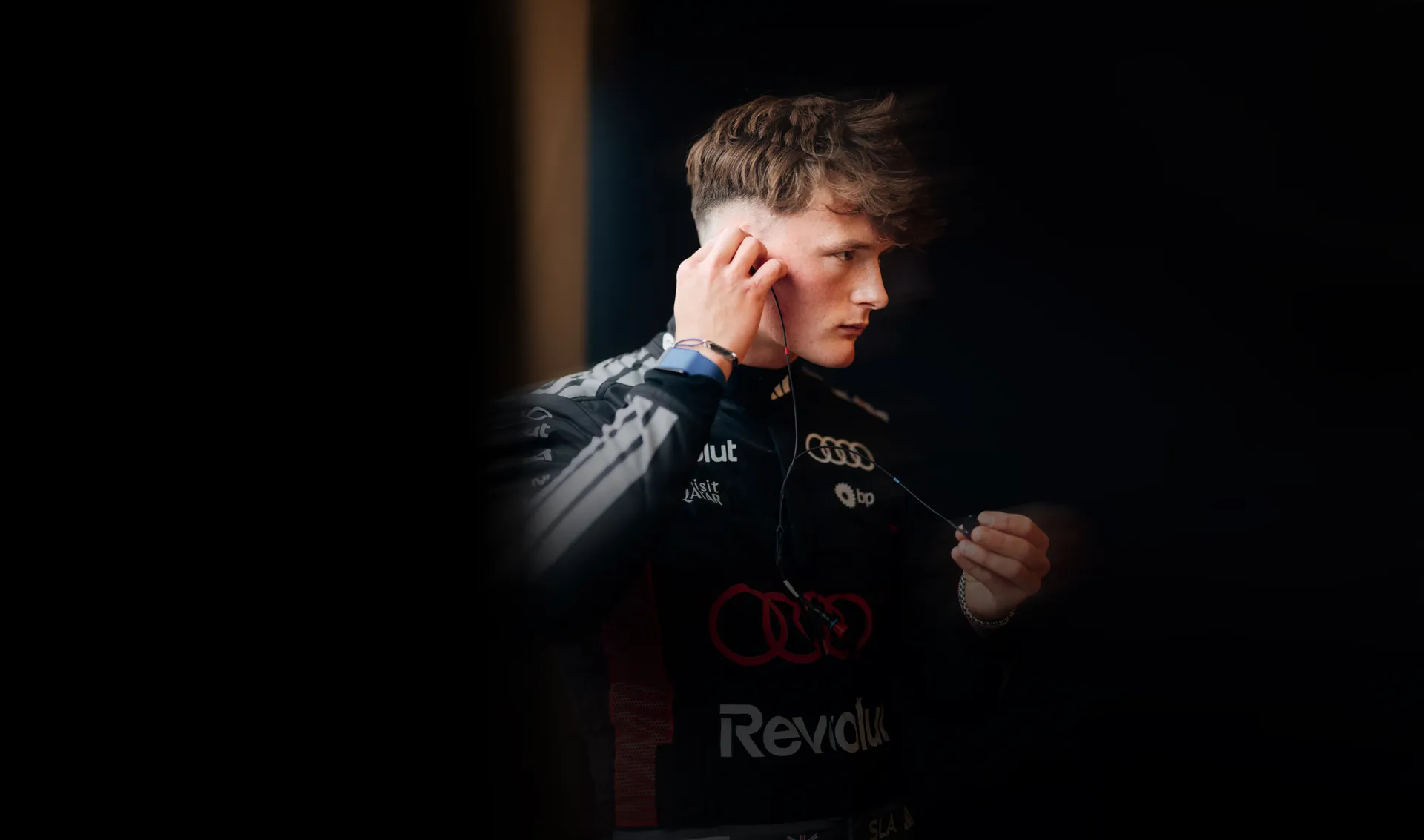 Freddie Slater of the Audi Driver Development Programme fitting an earpiece in an Audi Revolut F1® Team race suit