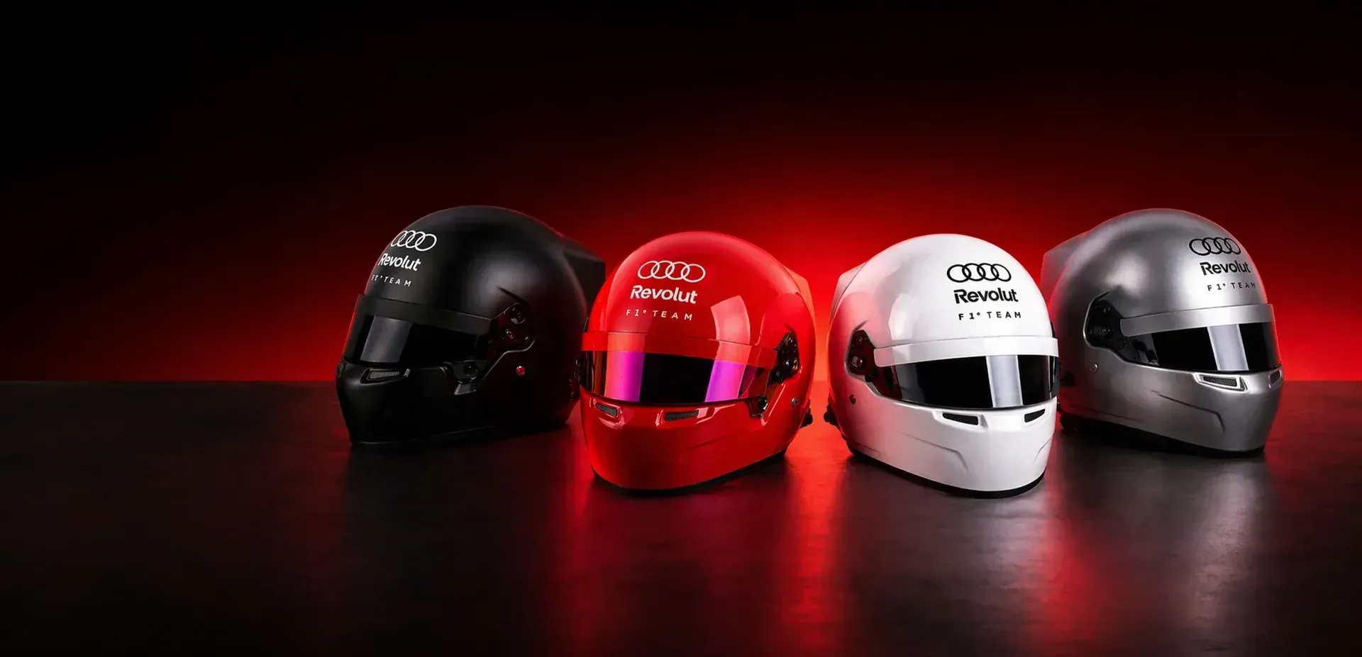 Close up of the Audi Revolut F1® Team Miami pantone helmets in dramatic red studio light