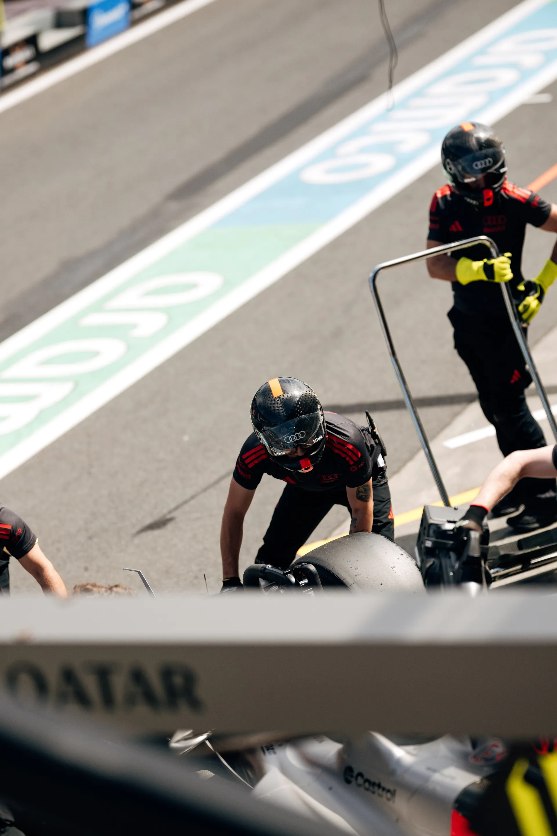 Audi Revolut F1® Team pit crew prepare equipment and tires in the Melbourne pit lane during qualifying.